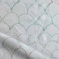 A close up of white fabric with fish scales on it, showcasing Baby Scallop Fabric Sage