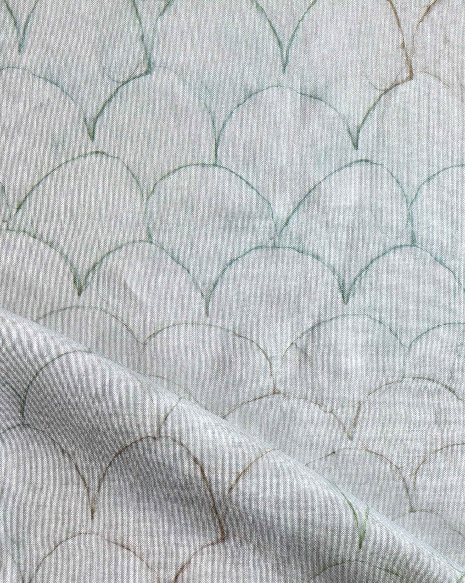 A close up of white fabric with fish scales on it, showcasing Baby Scallop Fabric Sage