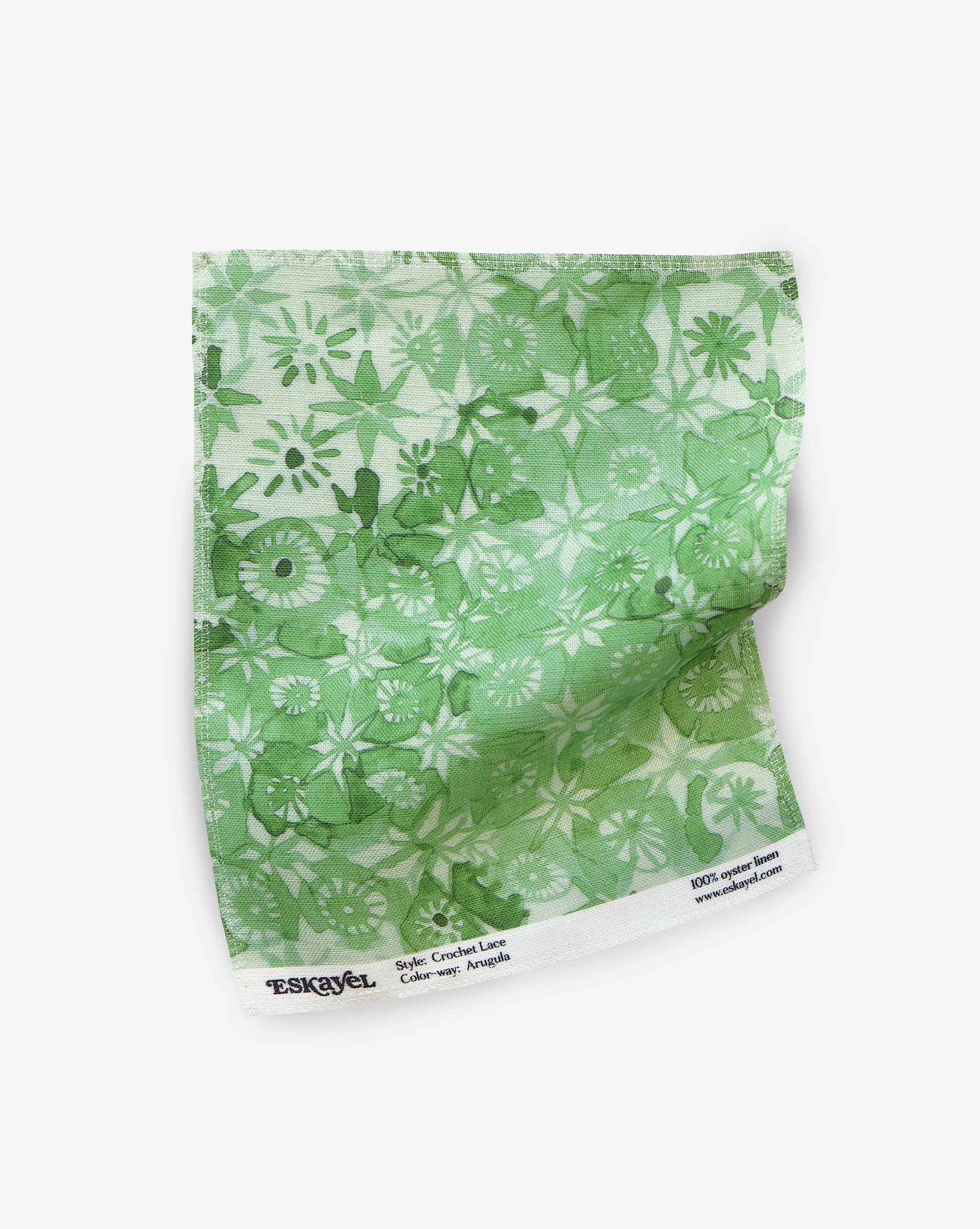 Eskayel’s Crochet Lace fabric swatch in the colorway Arugula is in a green palette of micro-printed flowers. 