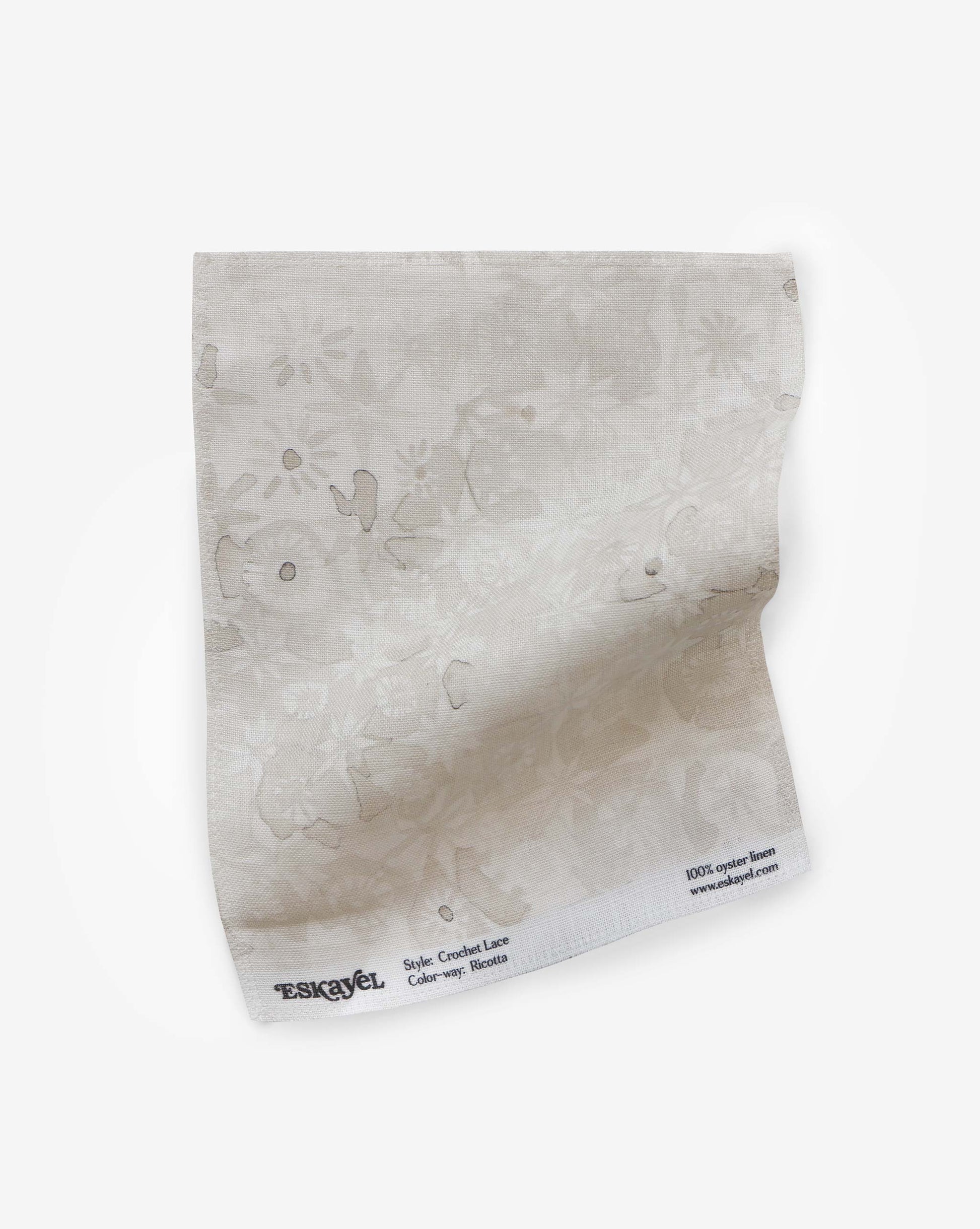 Eskayel’s Crochet Lace fabric swatch in the colorway Ricotta is in a beige neutral palette of micro-printed flowers.