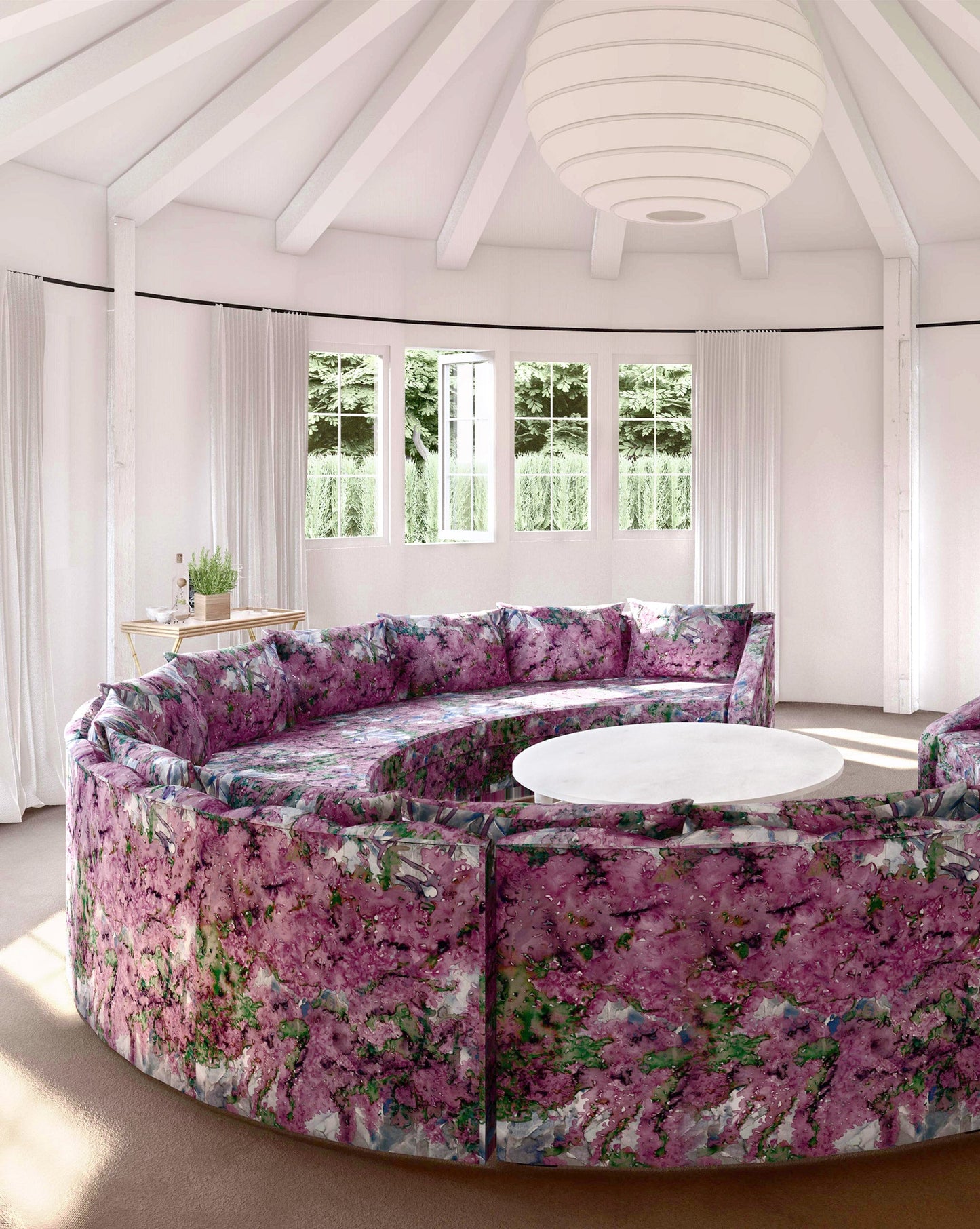 A living room with a circular couch and a coffee table adorned with Inflorescence Fabric Pomegranate geometric patterns