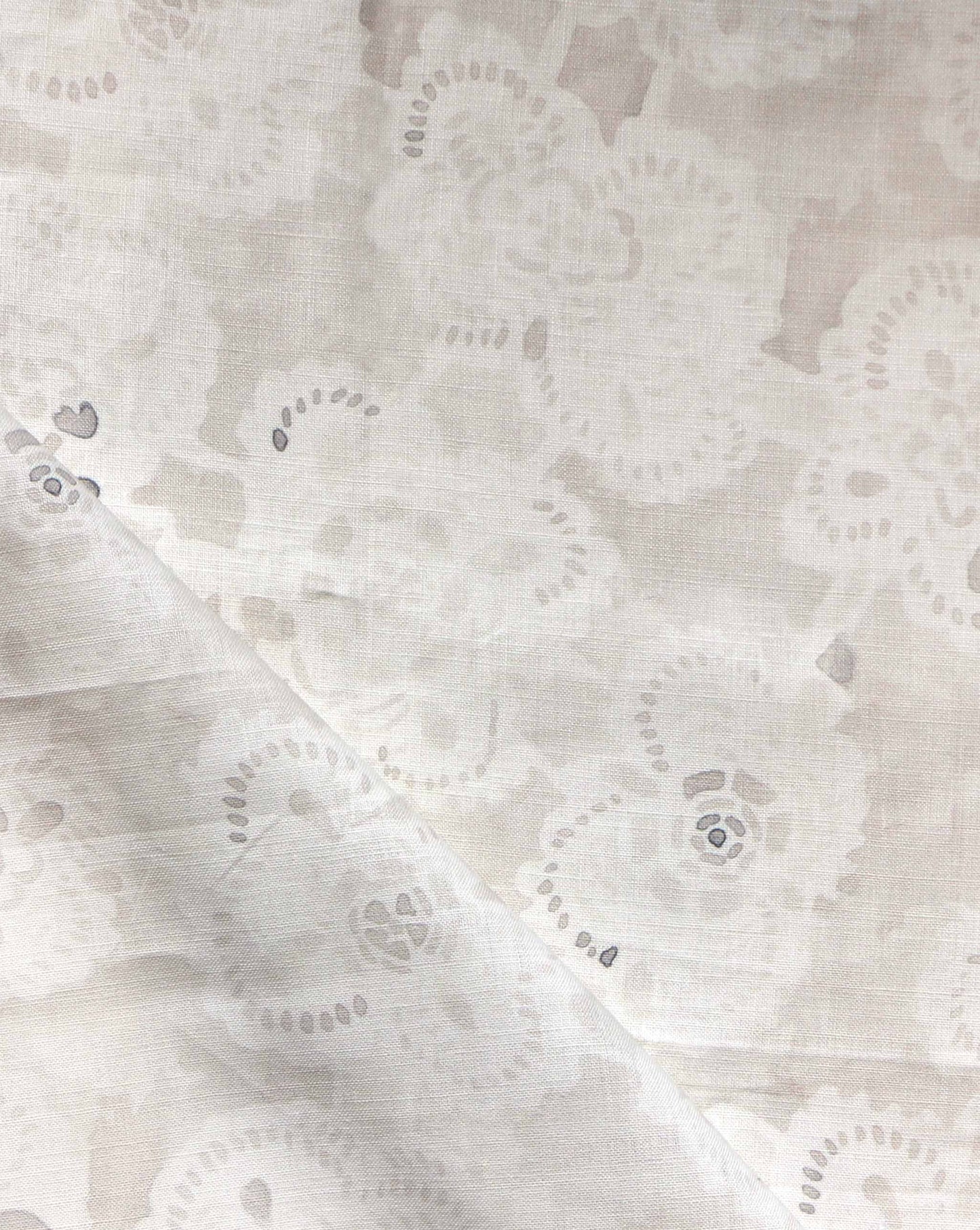 A close-up of Margherita Fabric||Ricotta, showcasing vintage handmade lace with a floral pattern and a diagonal fold across the lower left corner.