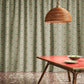 Orbs tourmaline fabric in a green toned pattern used as curtains in a dining room.