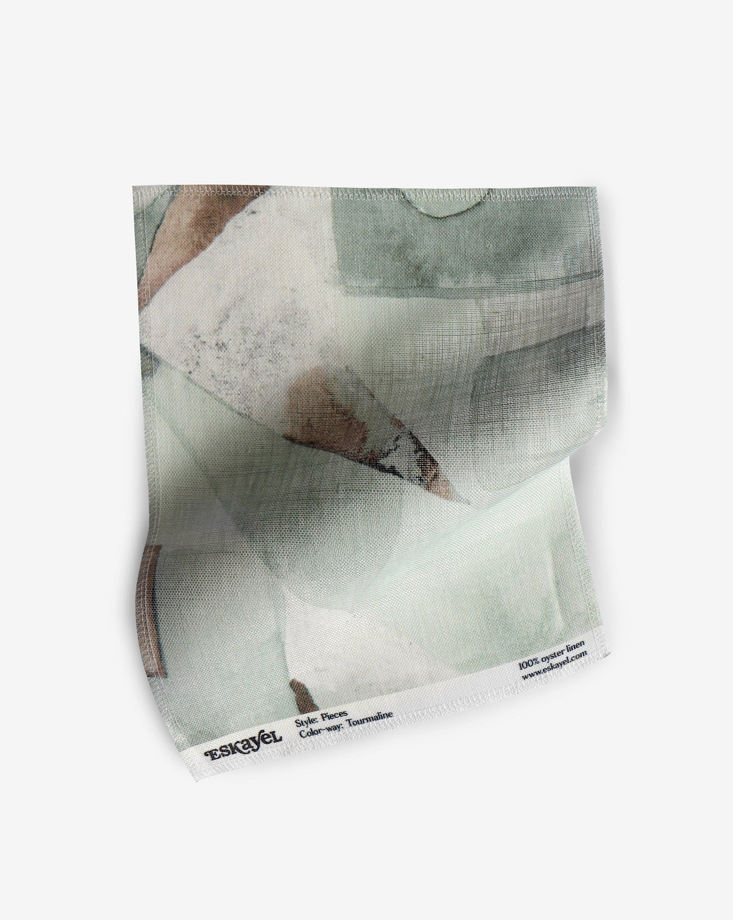 A fabric with our pieces pattern in tourmaline featuring a color blocked design of puzzle pieces in shades of green and a rusty brown throughout.