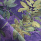 A detail photo of Eskayel’s Plumeria Shadows fabric pattern in Eggplant, a colorway of purple with green tones.