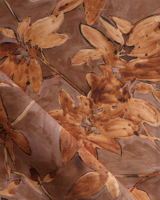 A detail photo of Eskayel’s Plumeria Shadows fabric pattern in Golden Hour, a colorway of rich brown and gold tones.