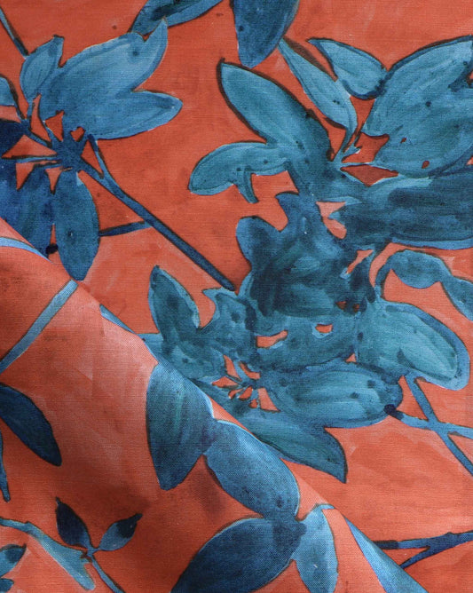 A detail photo of Eskayel’s Plumeria Shadows fabric pattern in the Hibiscus colorway featuring a rich red background.