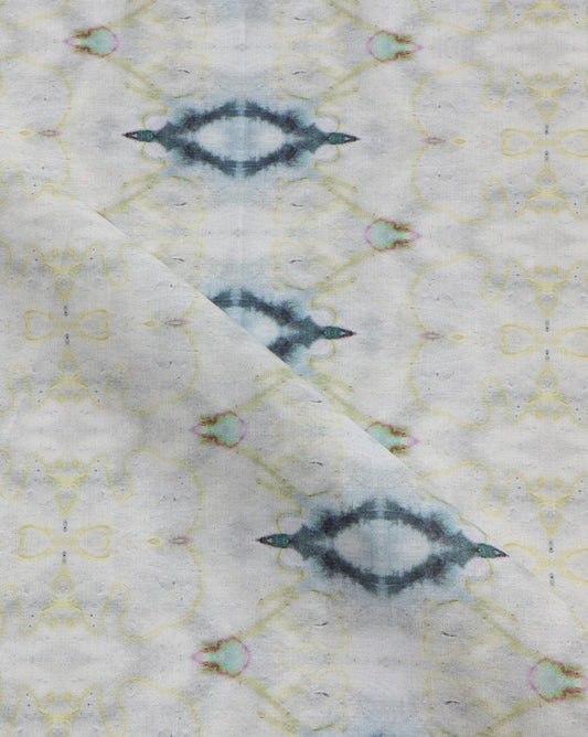 A close up of a white fabric from The Knitting Fabric Sand with a blue and yellow pattern