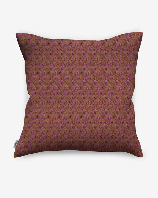 A pillow in Eskayel’s Alhelí fabric, a tiny repeat pattern inspired by tropical light, shown in the brown-based Rubra colorway.