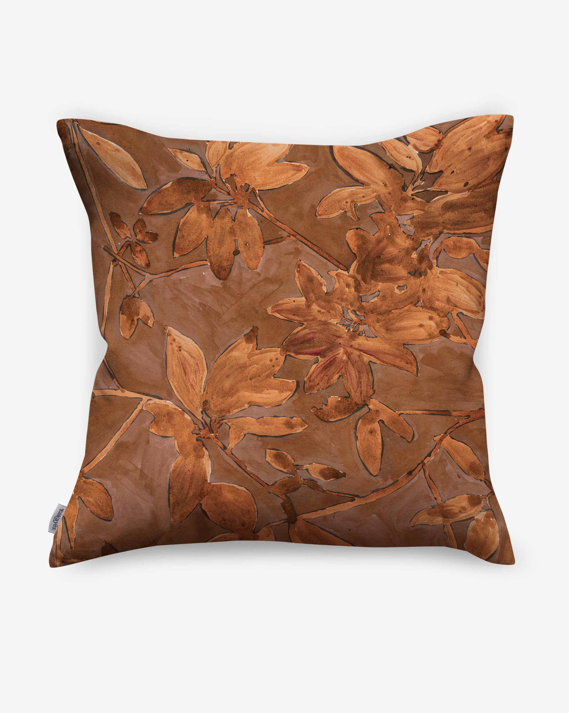 A photo of Eskayel’s Plumeria Shadows pillows in Golden Hour, a colorway of rich brown and gold tones.
