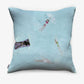The Swim Pillow in Sea features a light blue front cover with a playful print of four swimmers in a pool—perfect for adding beach house charm.