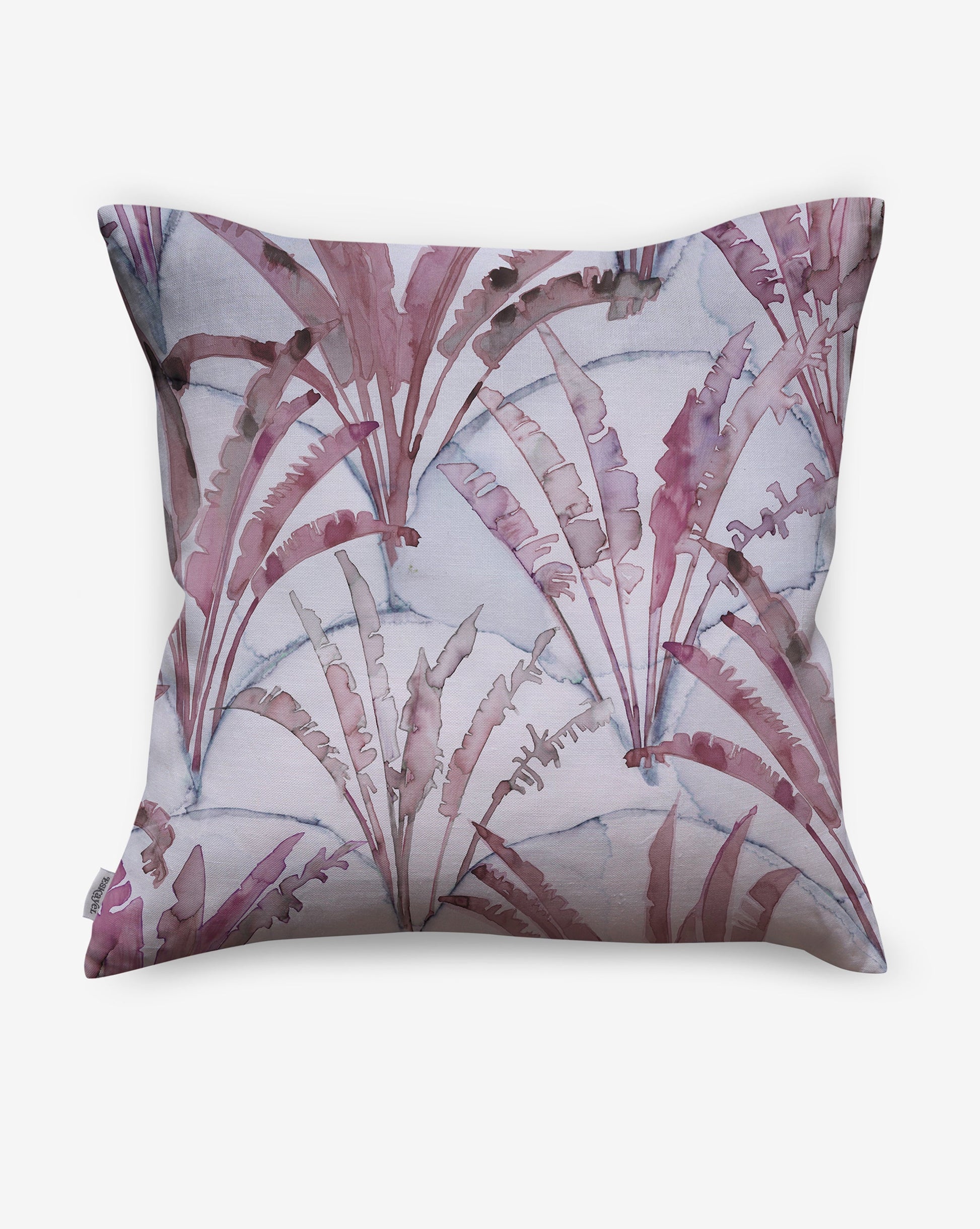 Displaying palms on a geometric scallop backdrop, Travelers Palm pillows in Pomegranate use a palette of magenta and light grey.