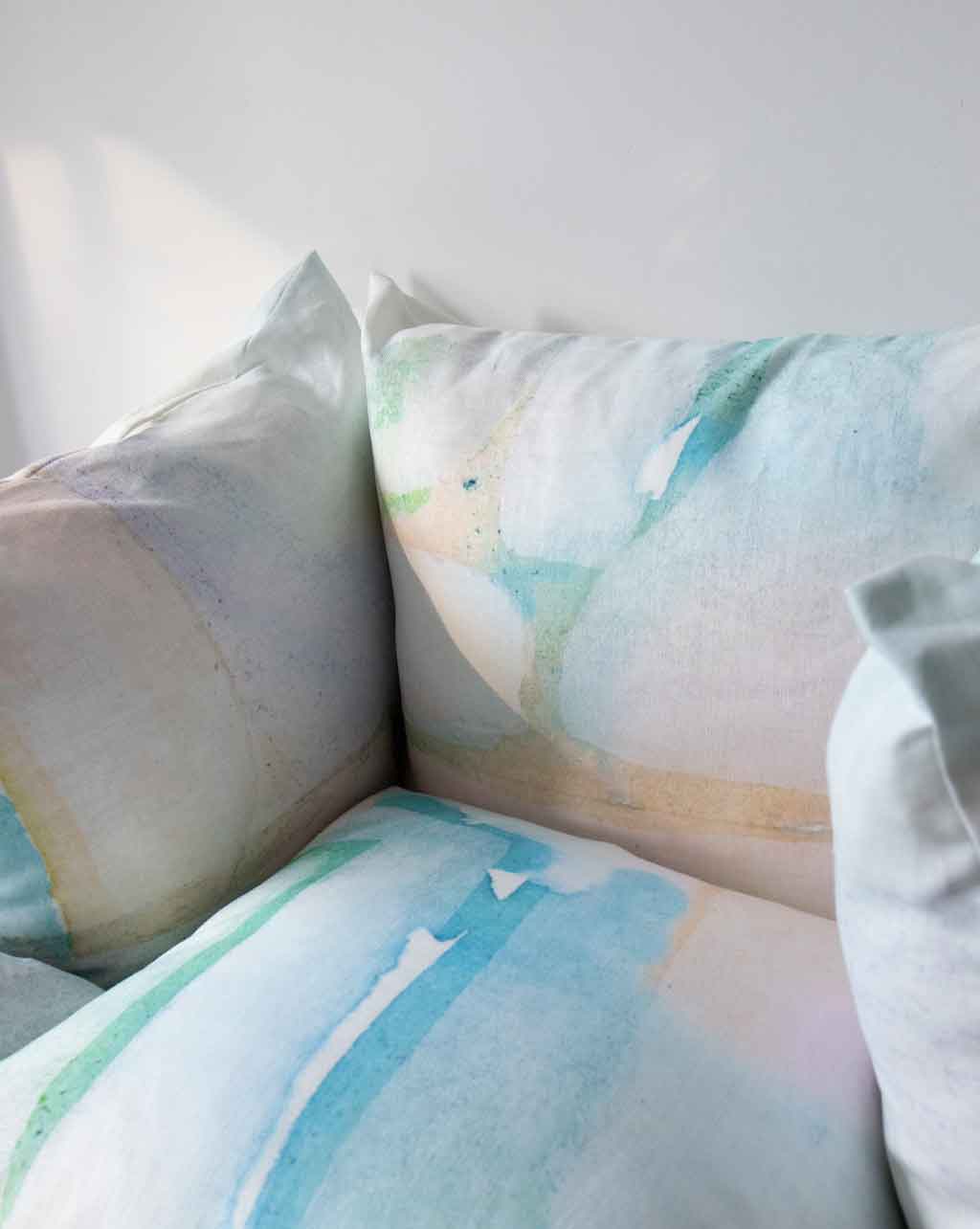 A pair of Custom Pillows with watercolor designs patterns on them