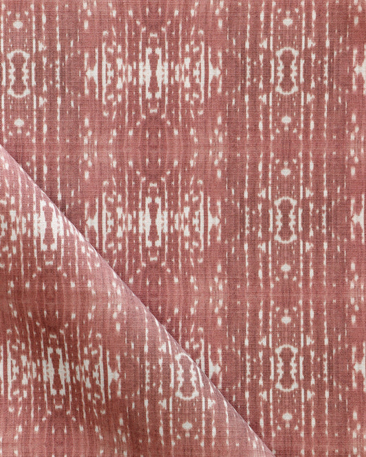 A pink and white Omaha Kinship Performance Fabric in the Morinda Ikat colorway with a geometric pattern