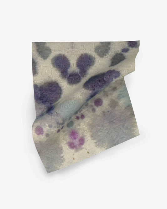 A a swatch of fabric with an abstract pattern of blue, purple, and grey ink blots, reminiscent of the Species Performance Fabric in the Waterstone colorway.