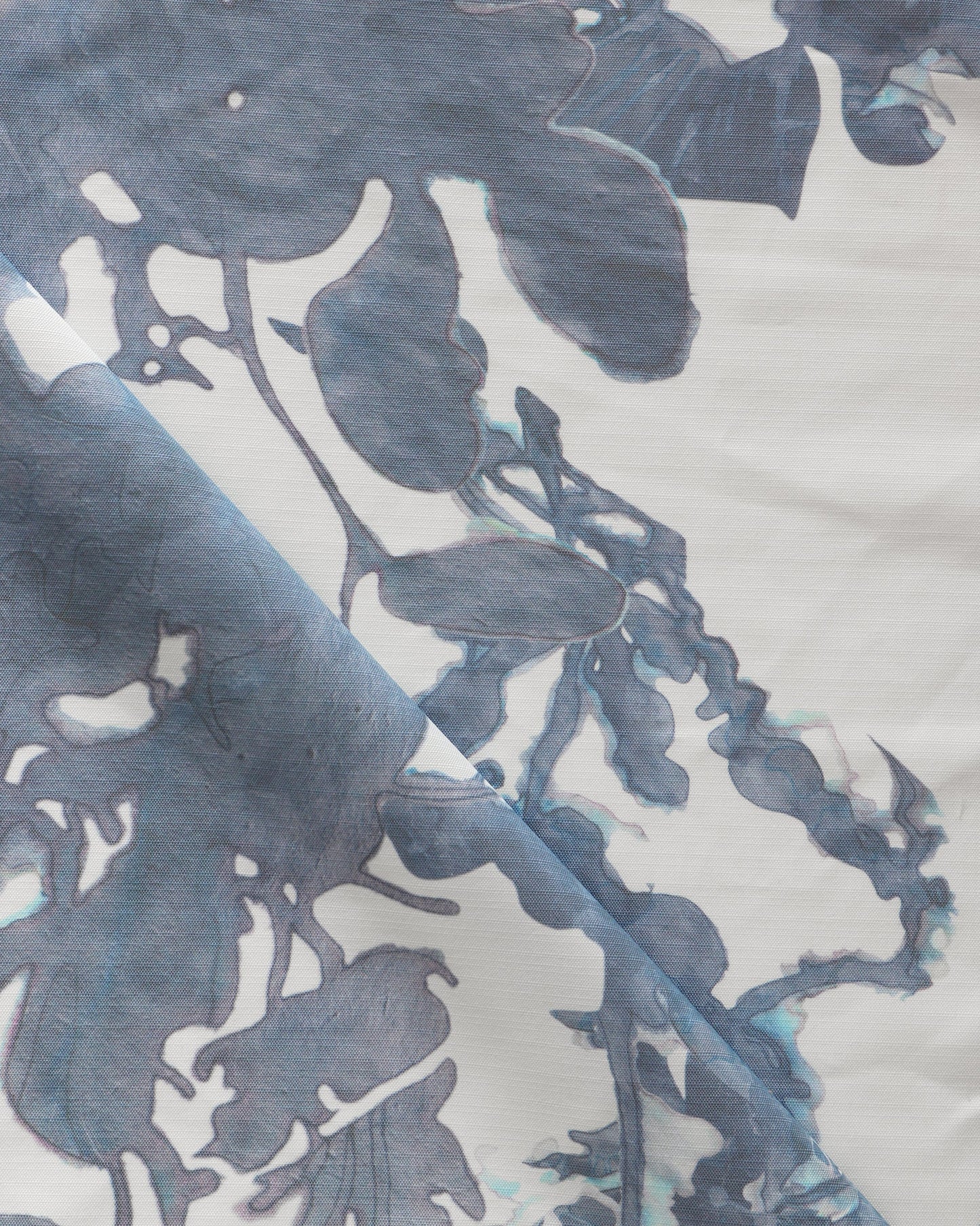 A close up of the Up for Anything Performance Fabric||Cerulean, a luxury performance fabric with a blue and white abstract botanical pattern suitable for high-traffic applications.