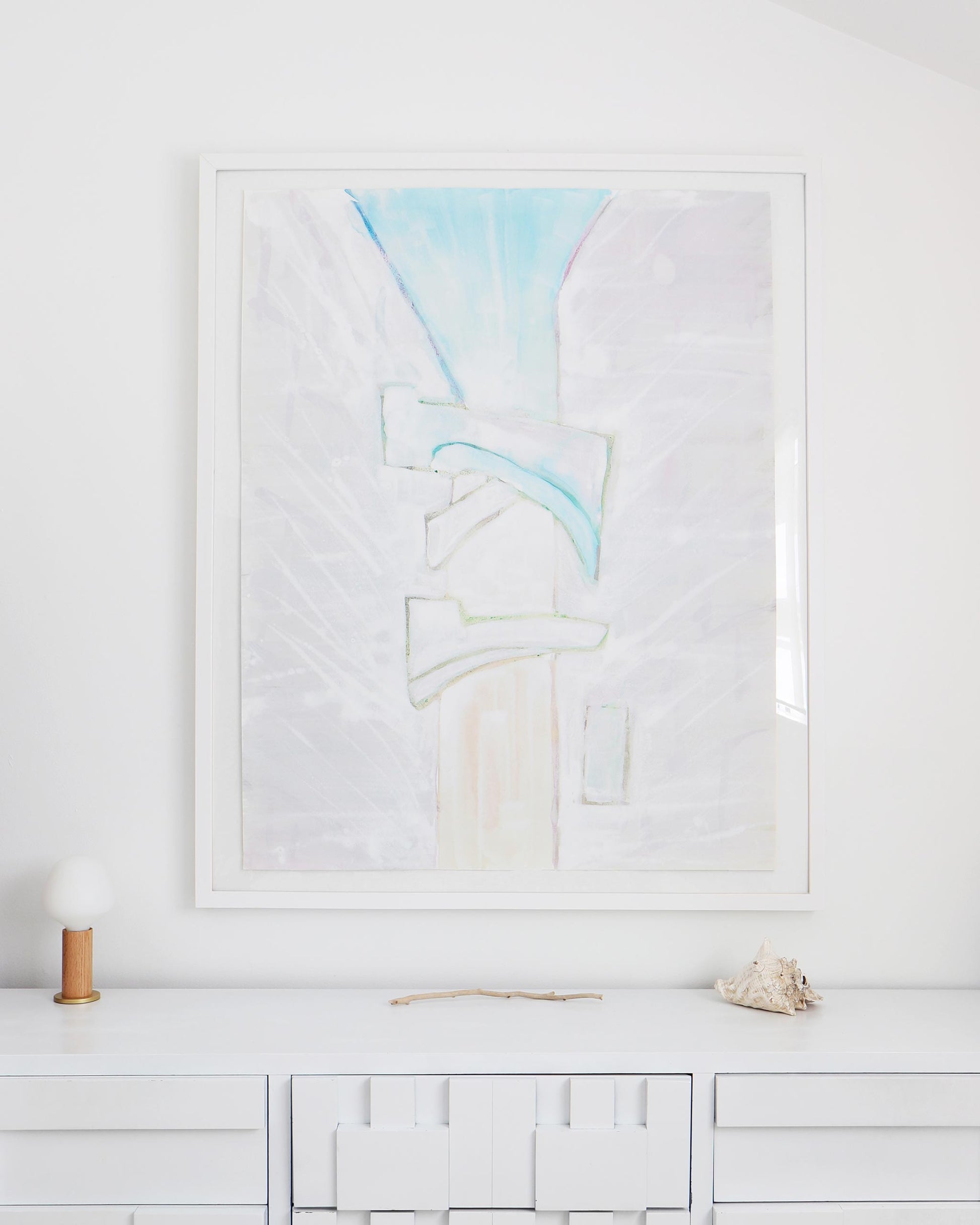 A white dresser with a Sky Arc Print 17" x 22" by Eskayel founder above it