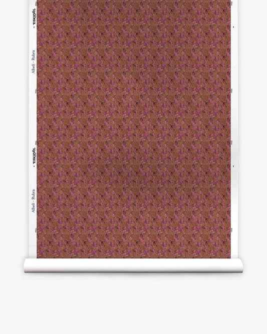 A roll of Alhelí Silk Wallcovering||Rubra wallpaper featuring a dense, brown and magenta botanical pattern with white trim margins on the sides.