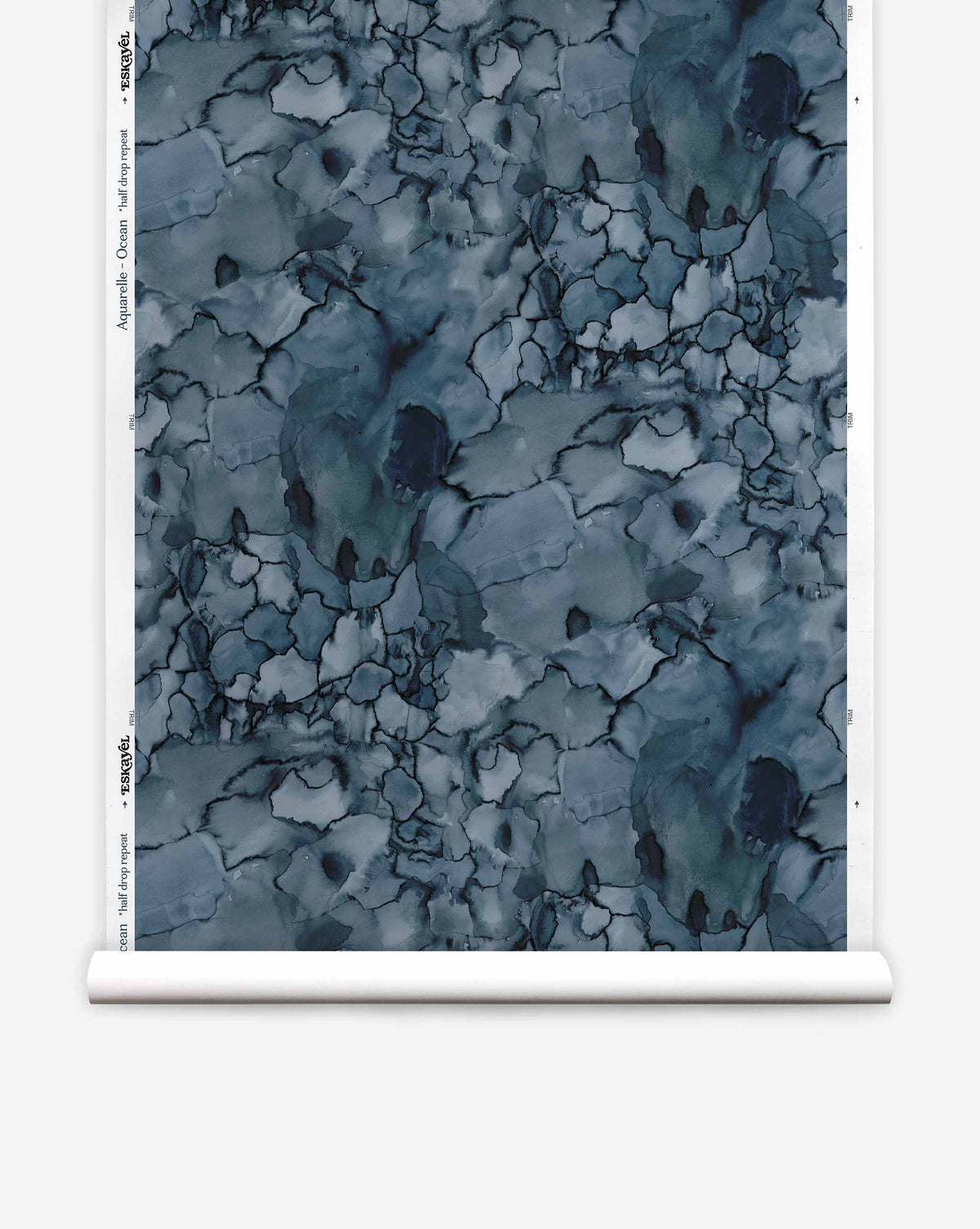 A roll of Aquarelle Silk Wallcovering in Ocean, featuring an abstract dark blue ink wash pattern with cracked, vein-like dark lines.