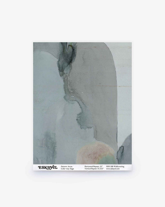 A sample swatch of wallpaper featuring abstract watercolor patterns in muted gray and beige tones is shown. The label below reads “ESKAYEL — Arcos Silk Sample||Sage,” displaying product and pattern details to make ordering a sample for your space quick and easy.
