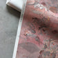 A close up detailed shot of Eskayel’s Atoll wallpaper in Coral with its red hues. 