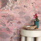 Eskayel’s Atoll wallpaper in Coral with its red hues is printed on a paper backed silk and installed in a room behind a stone stool.
