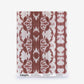 A rectangular swatch of Bali Stripe Silk Sample||Morinda Ikat wallpaper featuring a rust-colored ikat stripe pattern, with label text at the bottom and an Order Sample button.