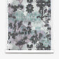 A roll of Clemente Silk Wallcovering in the Canyon colorway features an abstract, symmetrical pattern in shades of black, gray, and light blue with organic, cloud-like shapes. This custom wallcovering adds a modern touch to any space while evoking the gentle fluidity of botanical wallpaper designs.