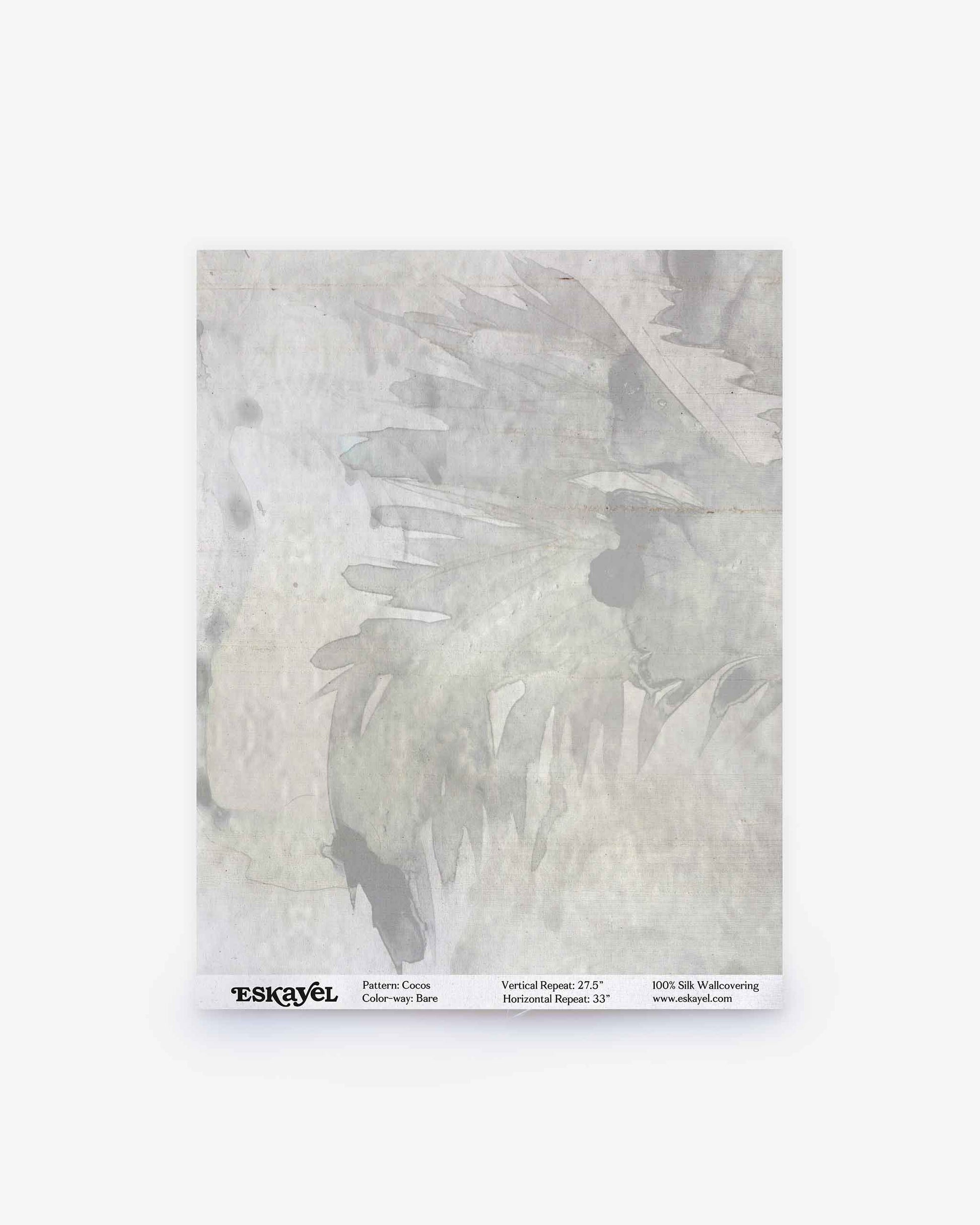A square sample of Cocos Silk wallpaper in the Bare colorway displays light gray abstract, feather-like brushstroke patterns with a subtle watercolor texture. The label at the bottom features product details and the Eskayel brand—ideal for previewing this luxurious design before ordering a sample for your space.