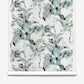 A roll of Cocos Silk Wallcovering||Chloros featuring a watercolor-style pattern with abstract leaves, palm tree motifs, and botanical shapes in shades of green, gray, and black.