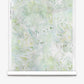 A roll of Cortile Silk Wallcovering||Luminosa, featuring a pale green and white abstract floral pattern inspired by an Italianate garden, is partially unrolled against a white background.