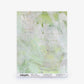 A sample of Cortile Silk Wallcovering||Luminosa featuring a light green and white abstract watercolor design, evocative of an Italianate garden, displayed on a square sheet with product information at the bottom.