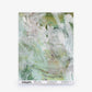 A sample of Cortile Silk Wallcovering||Verde, featuring an abstract green and white watercolor pattern, is displayed upright on a white surface and labeled “ESKAYEL” at the bottom.