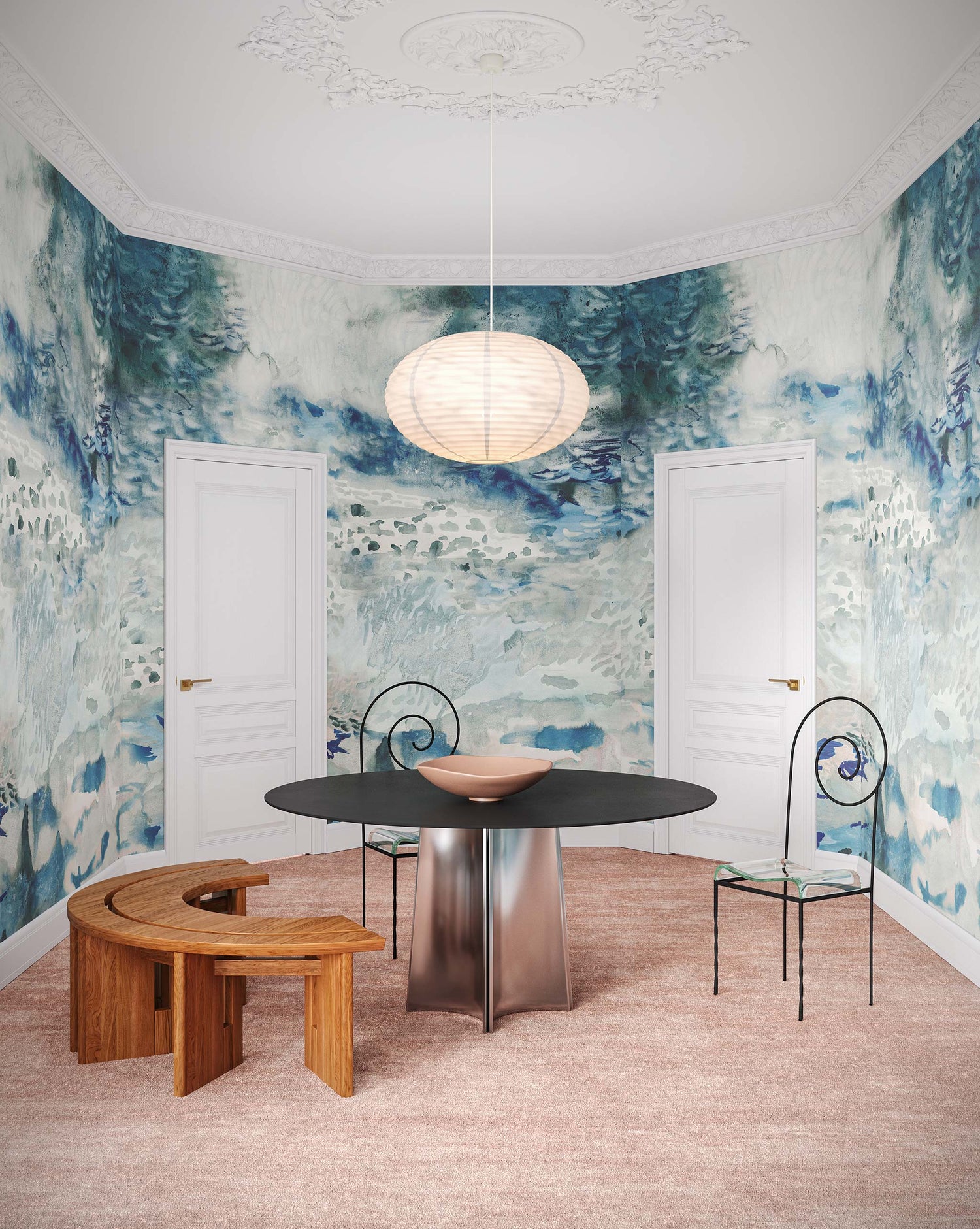 A modern room with a round black table, two artistic chairs, a wooden bench, and a large pendant light. The walls feature the Empyrean Silk Mural in the Cyrrus design, reminiscent of blue and white Maldivian atolls, and there are two white doors in the background.