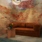 A cozy room features a rust-colored corduroy sofa, a round glass table with a flower vase, and the Empyrean Silk Mural||Sol abstract watercolor wall mural under diffused ceiling lighting, showcasing the epitome of high-end interior projects.