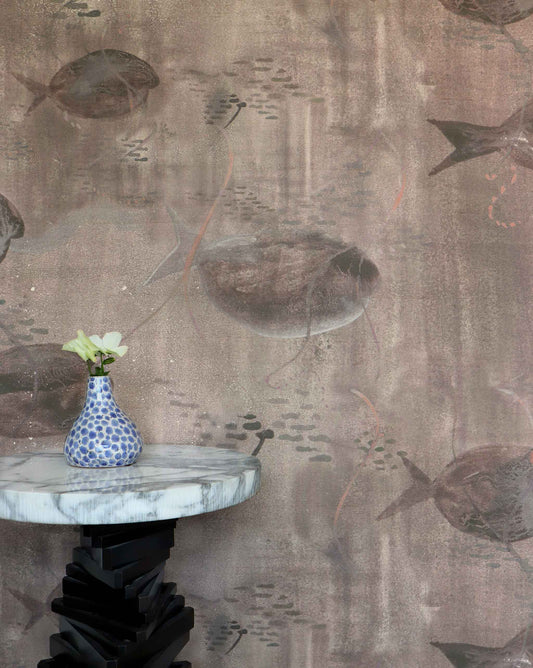 Eskayel’s Shoal wallpaper in Amber with its brown hues is printed on paper backed silk and installed in a room behind a marble table with a vase on top.