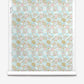 Yaya Silk Wallcovering Brisa roll featuring a repeating pattern of soft blue, pink, and gold abstract shapes over a light checkered coastal background.