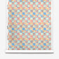 Yaya Silk Wallcovering in Punch, a paper-backed silk wallpaper with a repeating grid of squares featuring blue, pink, and orange abstract organic shapes.