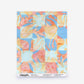 Yaya Silk Sample in Punch wallcovering swatch featuring a checkered pattern of light blue and watercolor-style coral, orange, and gold abstract floral shapes.