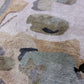 Close up image of our hand knotted Medina Blanca rug with abstract designs in a color palette of tans, greys, and black | Eskayel
