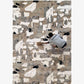 A rectangular abstract-patterned rug in beige, gray, white, and black, shown from above with a person sweeping on top of it.