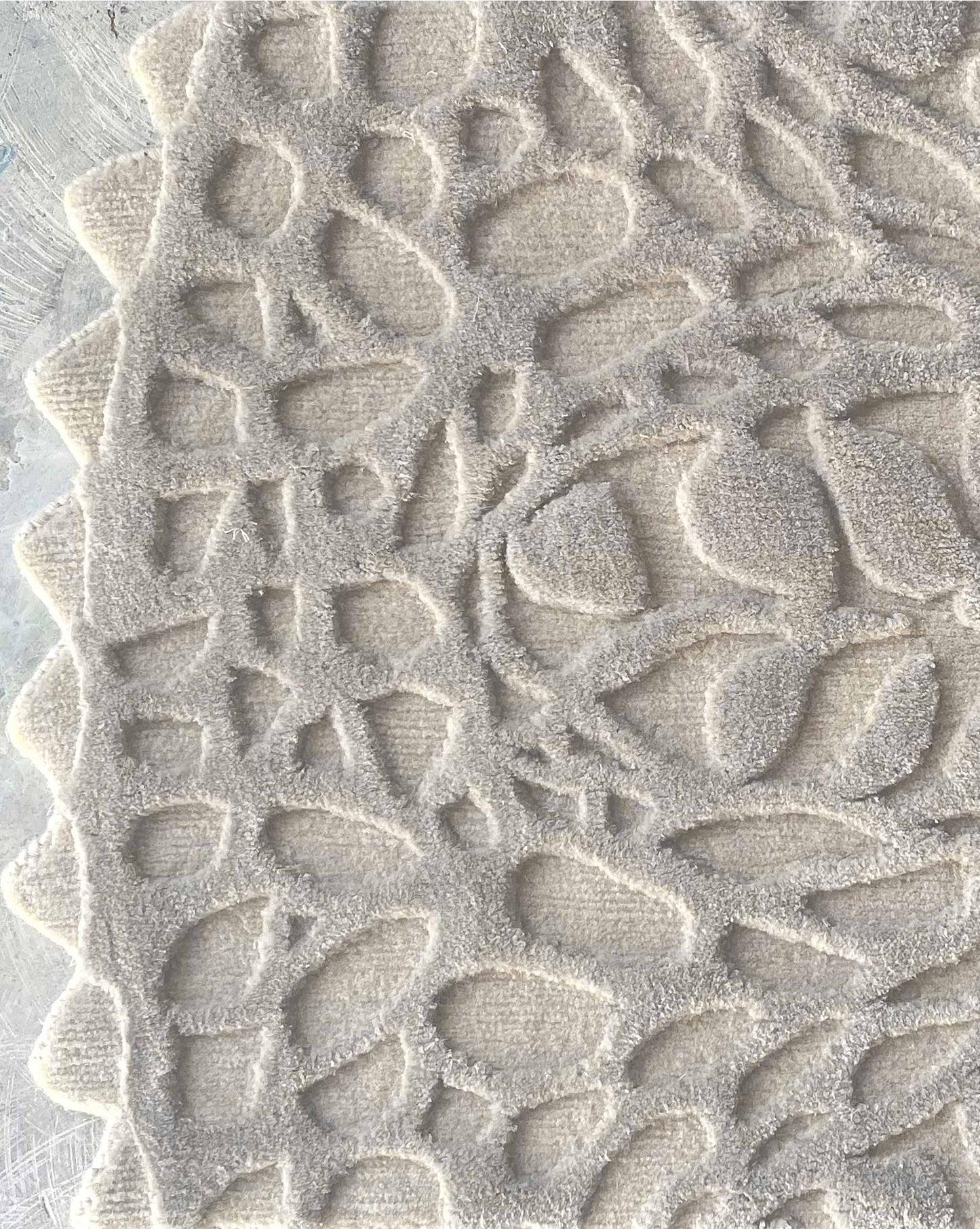 In the Blanca colorway, a Nonna’s Lace rug swatch shows the silk and wool pattern in creamy beige neutral tones.