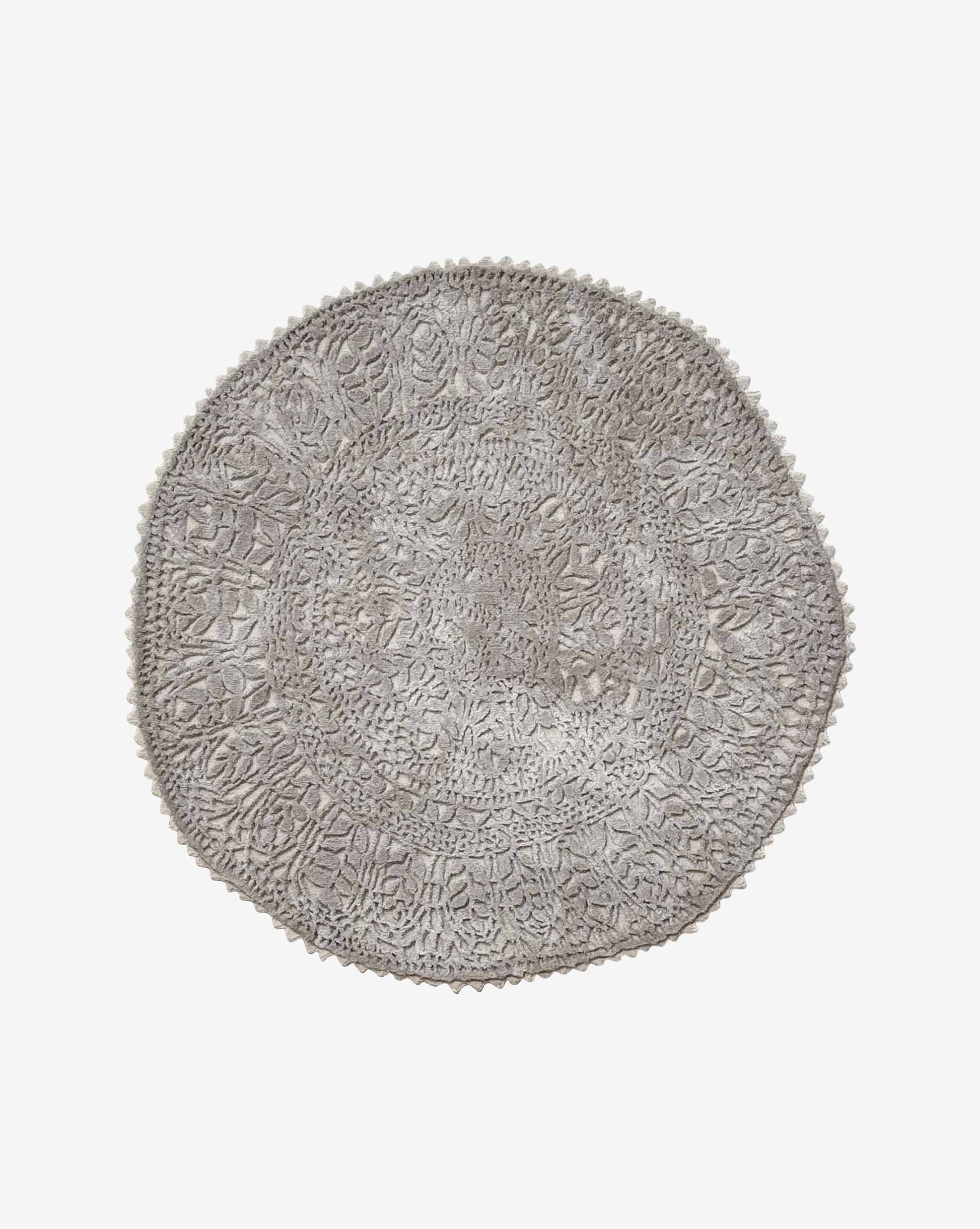 Hand-cut and hand-finished, a Nonna’s Lace rug in the Blanca colorway is a round design in creamy beige silk and wool.