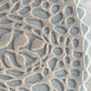 In the Cielo colorway, a Nonna’s Lace rug swatch shows the silk and wool pattern in blue and neutral tones.