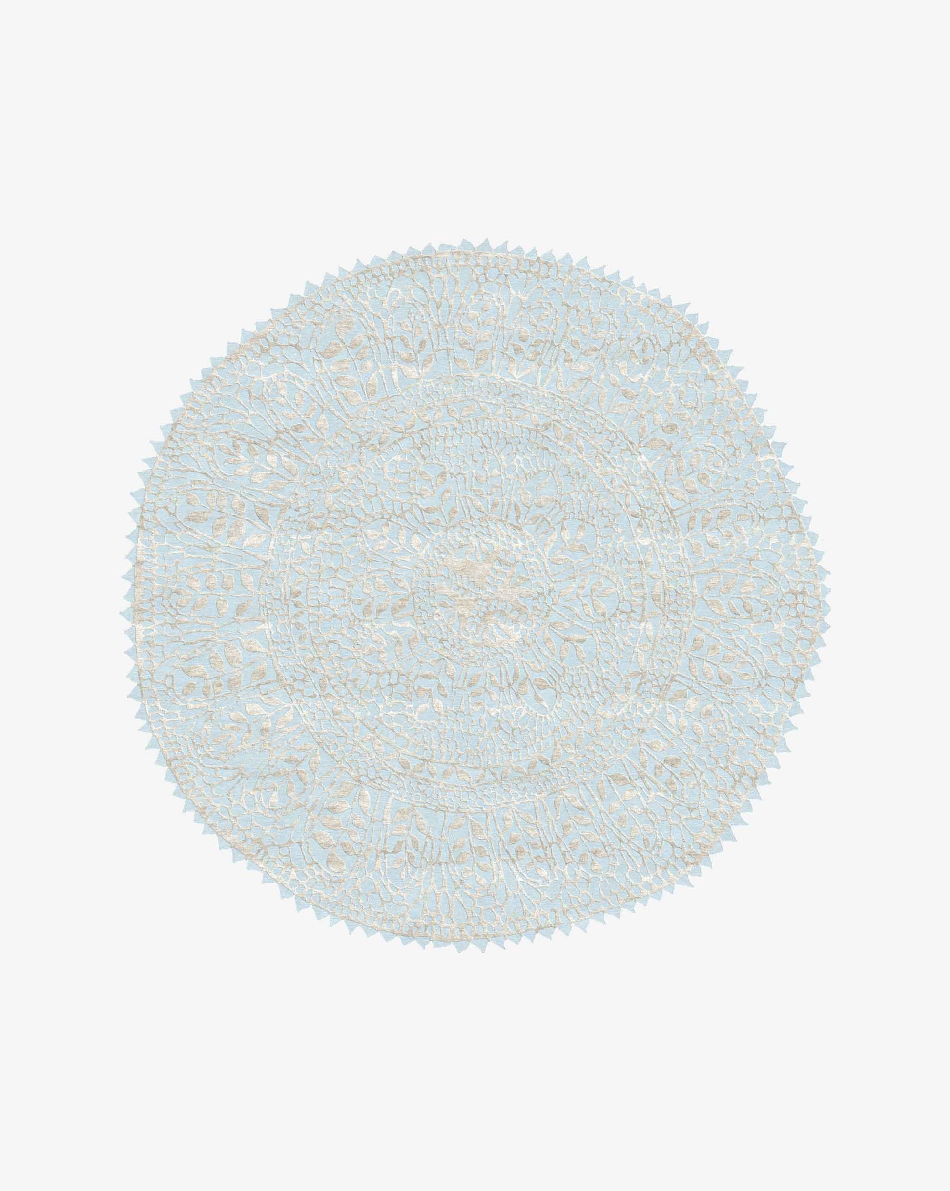 A Nonna’s Lace rug in the Cielo colorway is a round design in silk and wool with a blue background against a neutral high-pile lace pattern.
