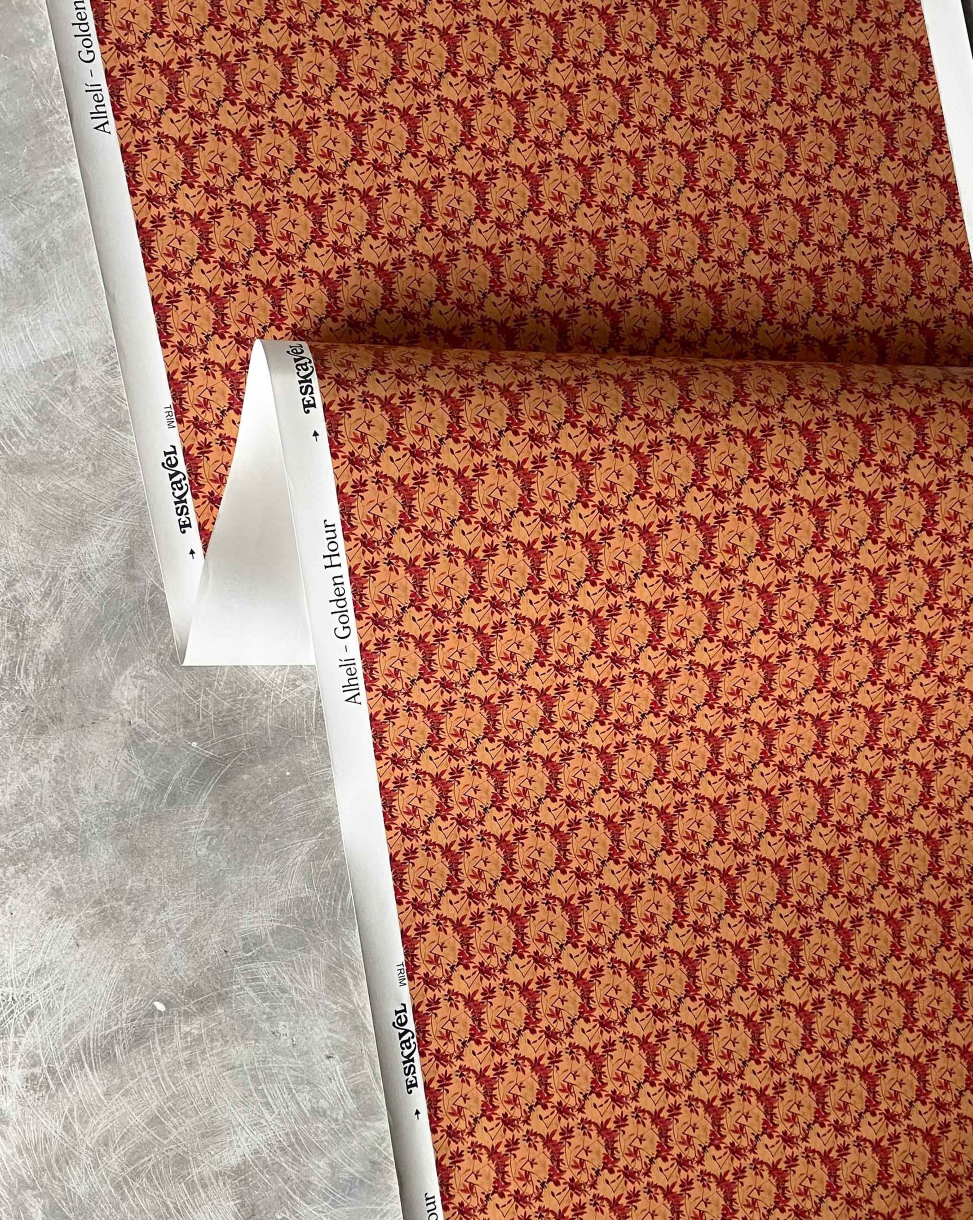 Eskayel’s Alhelí wallpaper, a tiny repeating pattern inspired by tropical living, in the orange-based colorway Golden Hour.