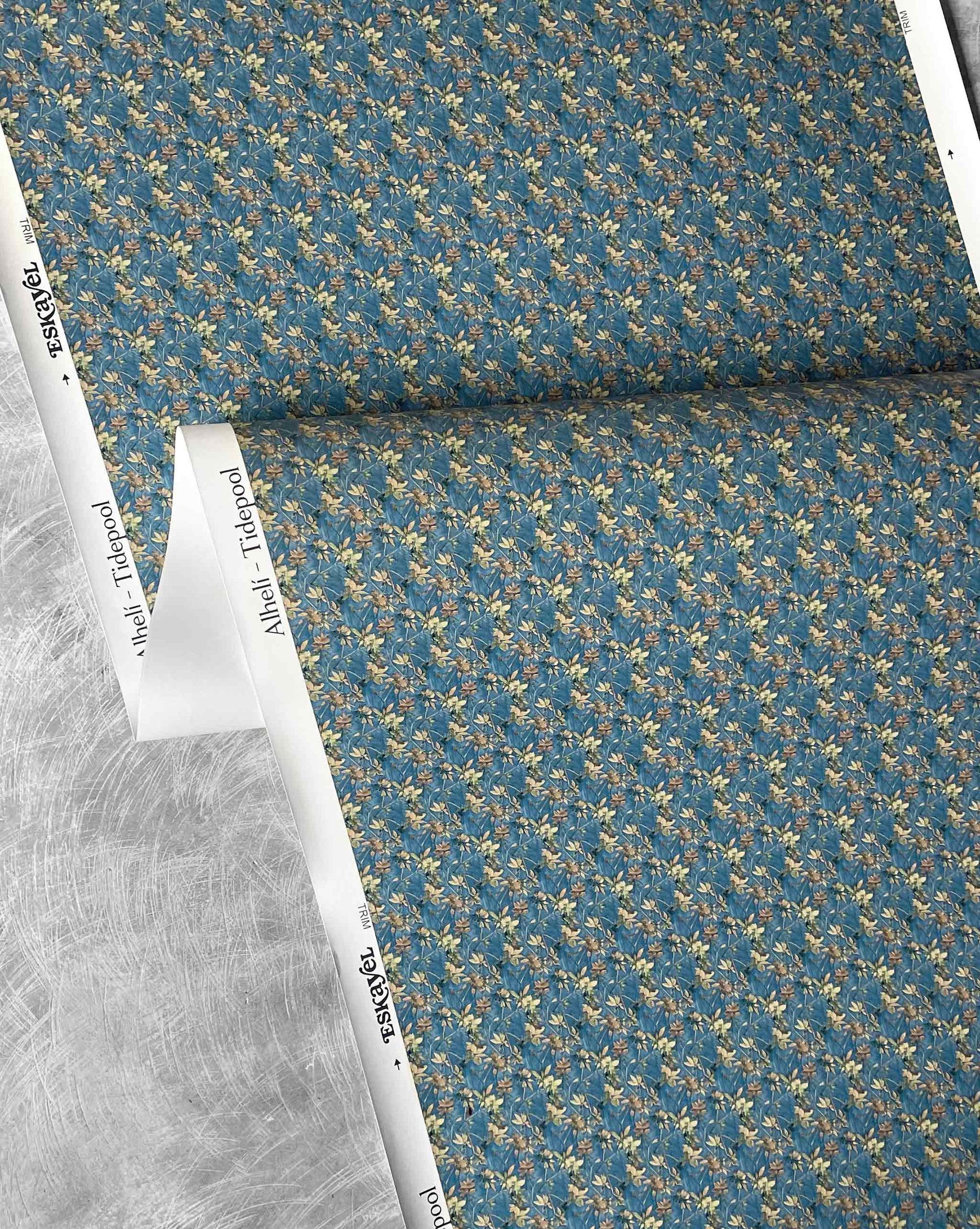 A close-up of Eskayel’s Alhelí wallpaper, a tiny repeat pattern inspired by tropical light, shown in the blue-based Tide Pool colorway.