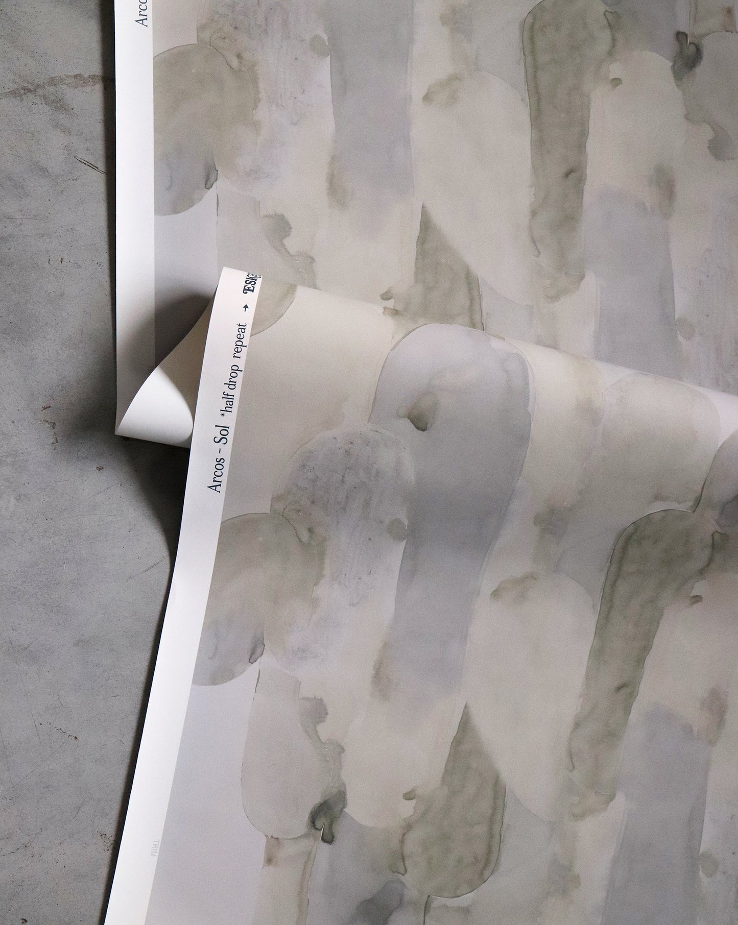 A grey and white pattern on the Arcos Wallpaper Sol collection