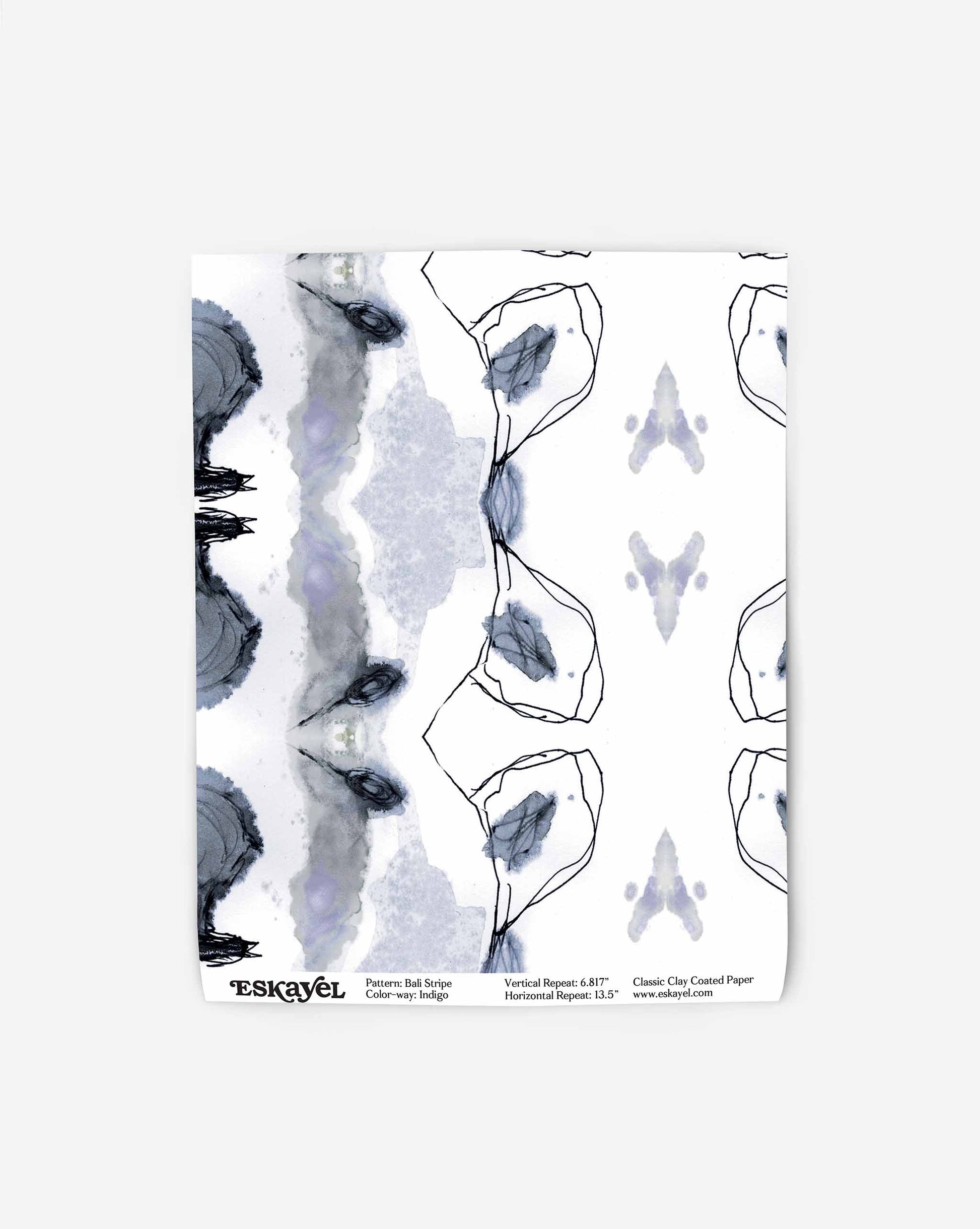 Abstract art print with a symmetrical pattern featuring black outlines and soft purple, gray, and blue watercolor splotches. The design evokes the elegance of high-end wallpaper. Text at the bottom reads: "Pattern: Bali Stripe Wallpaper||Indigo.
