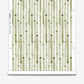 A roll of Eskayels Bamboo Stripe wallpaper in the colorway Brush with a water color style of green and white.